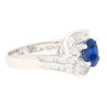 Natural 1.14 Carat Oval Cut Blue Sapphire with Round & Baguette Cut Diamonds in a Swirled 18K White Gold Ring Setting